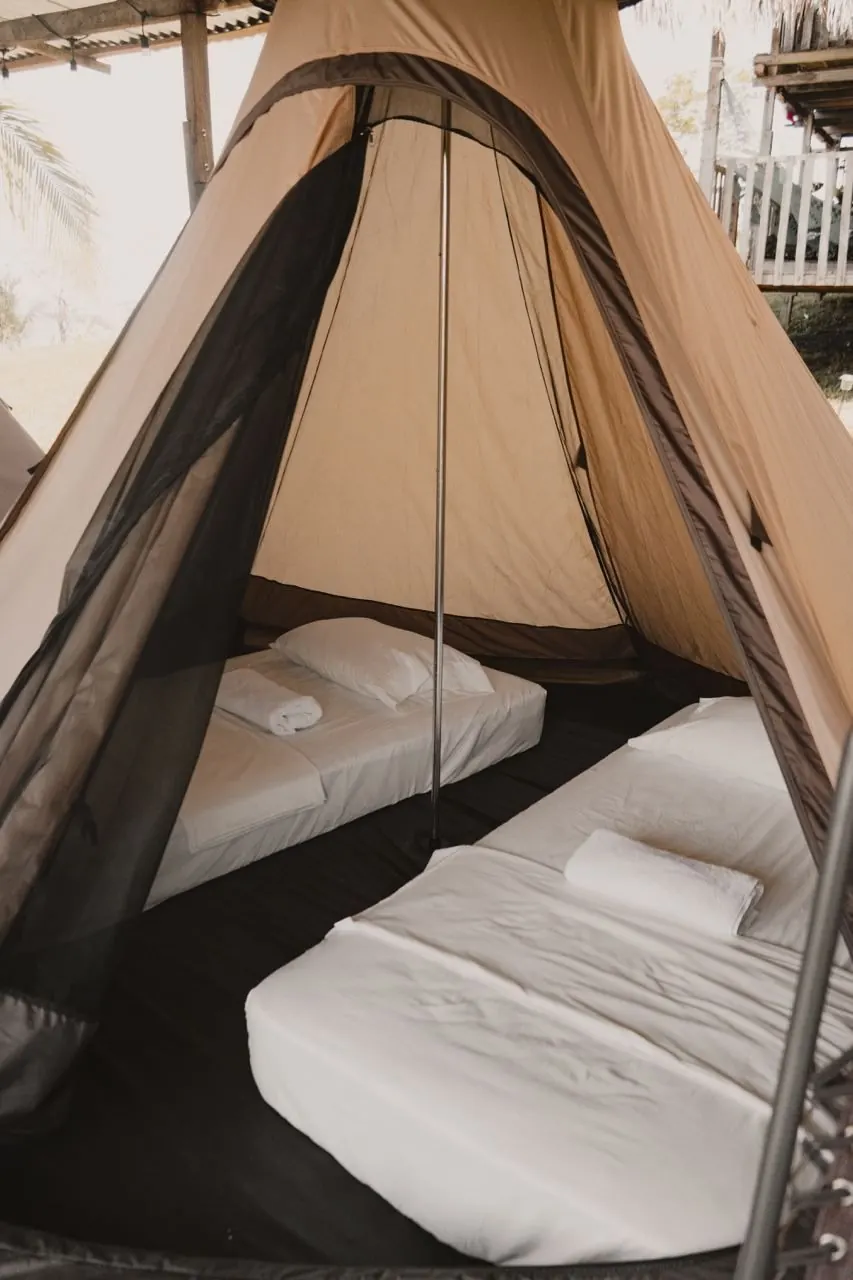 Vista desde dentro del tipi, con la malla mosquitera recogida junto a las colchonetas y almohadas.