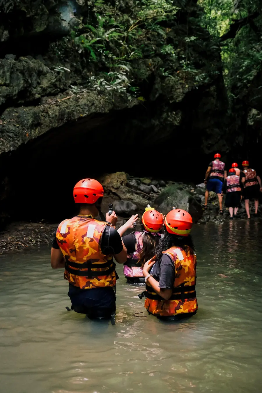Grupo con casco y chaleco avanzando dentro de la cueva