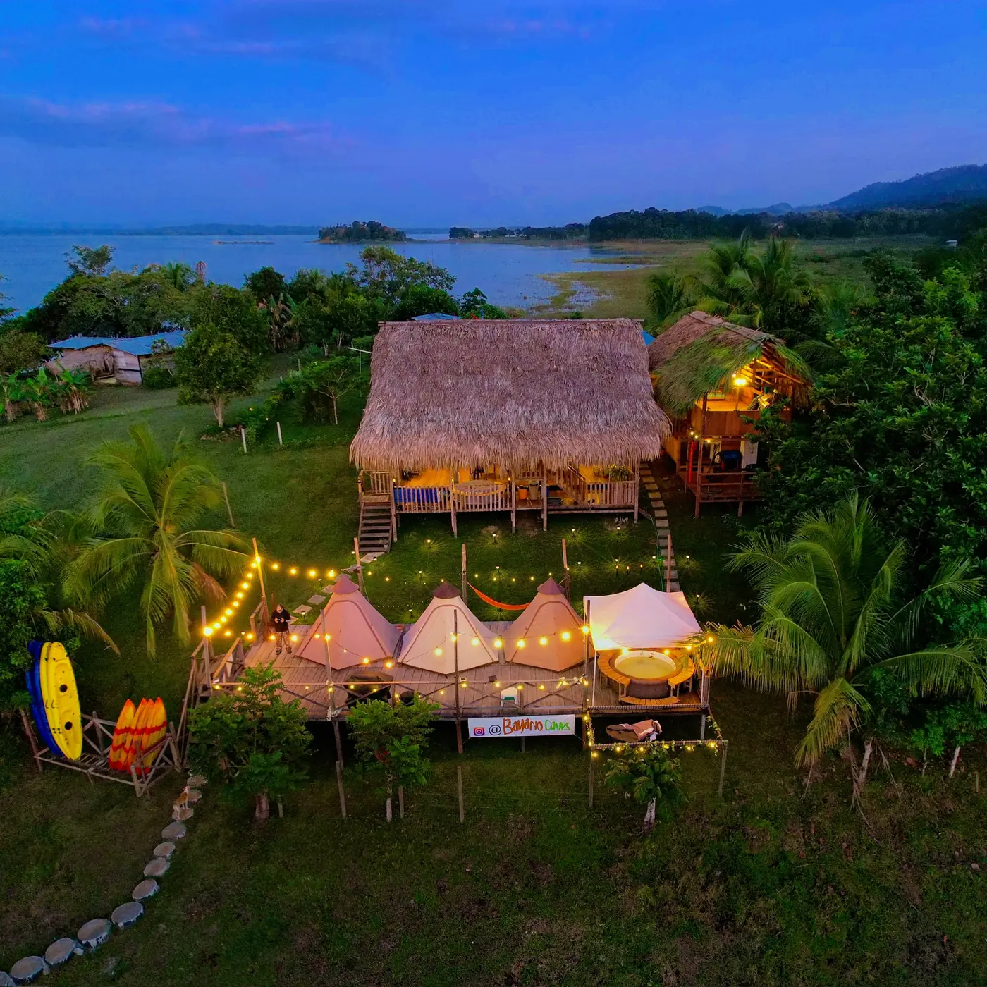 La propiedad vista desde el lago, con la casa principal y la fila de tipis