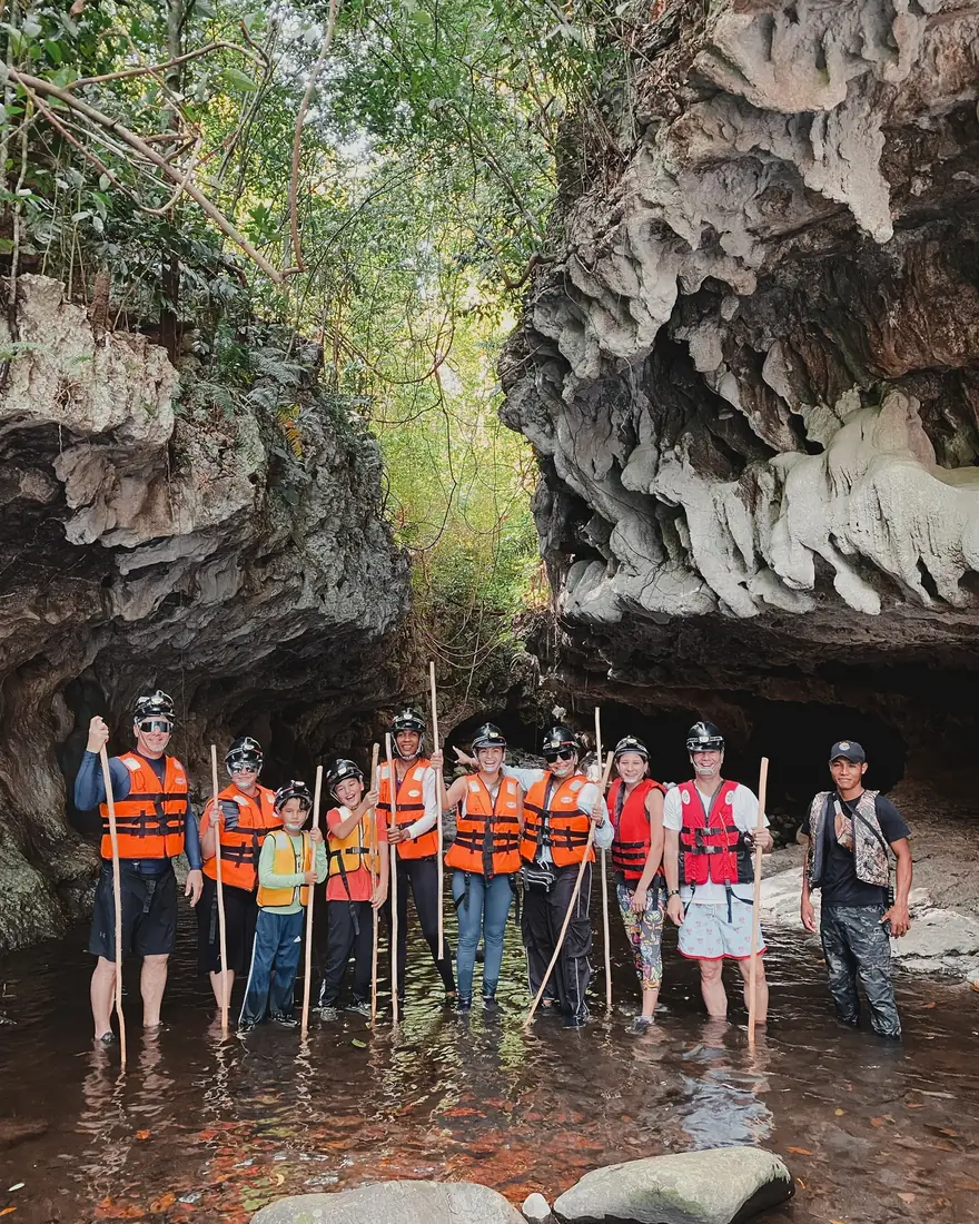 Grupo con casco y salvavidas a la entrada de la cueva