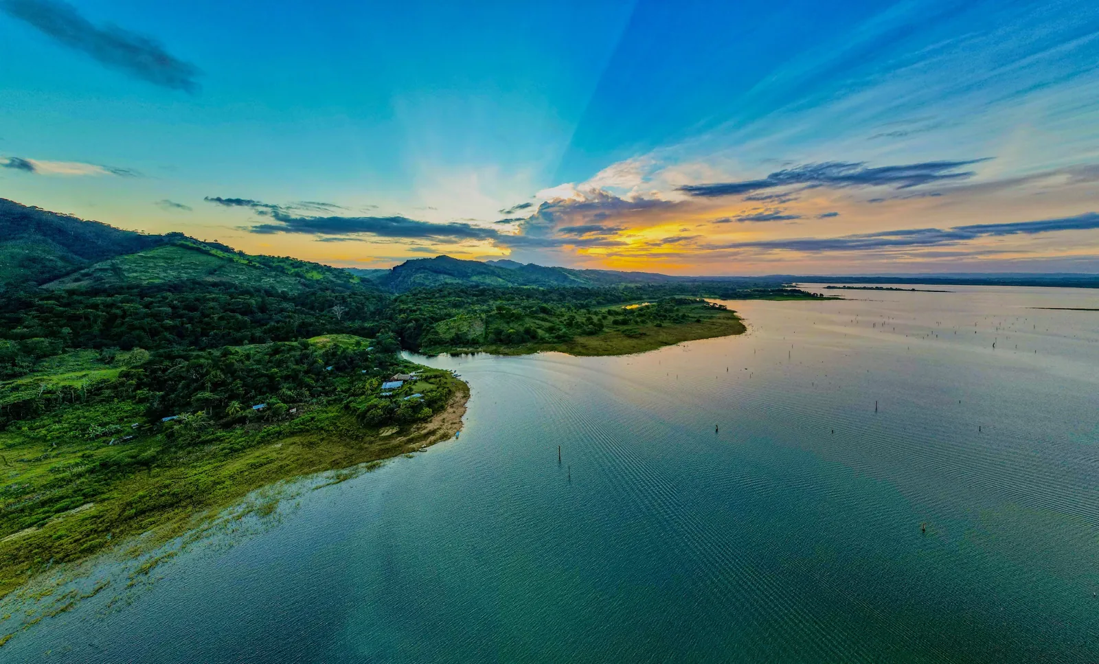 El Lago Bayano visto desde el aire al atardecer, con la orilla de selva y el agua turquesa
